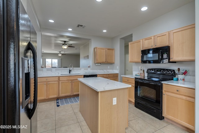 kitchen featuring a center island, visible vents, light tile patterned flooring, a sink, and black appliances