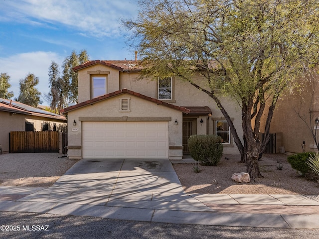 view of front of home with concrete driveway, fence, a tiled roof, and stucco siding