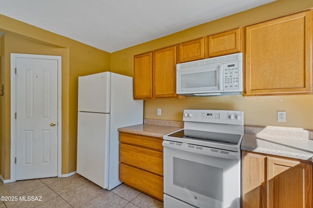 kitchen featuring light countertops, white appliances, light tile patterned flooring, and baseboards