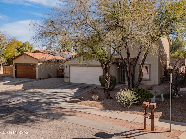 view of front facade featuring concrete driveway, a tiled roof, and stucco siding