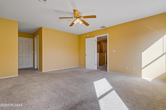 spare room featuring light carpet, ceiling fan, visible vents, and baseboards