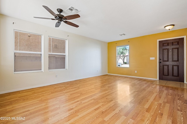 interior space featuring baseboards, visible vents, and light wood finished floors