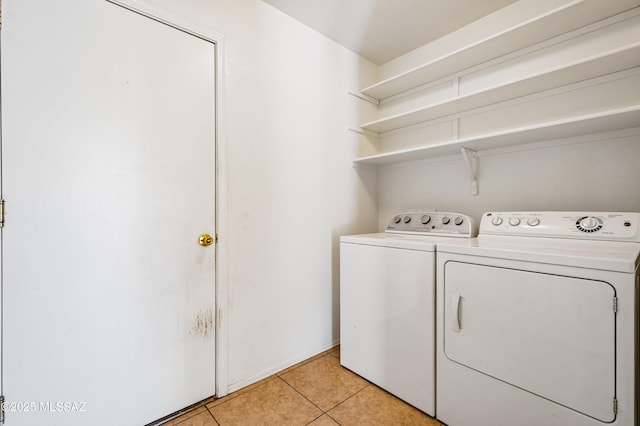 clothes washing area featuring light tile patterned floors, laundry area, and independent washer and dryer