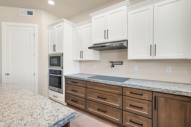 kitchen featuring stainless steel appliances, visible vents, under cabinet range hood, and white cabinetry