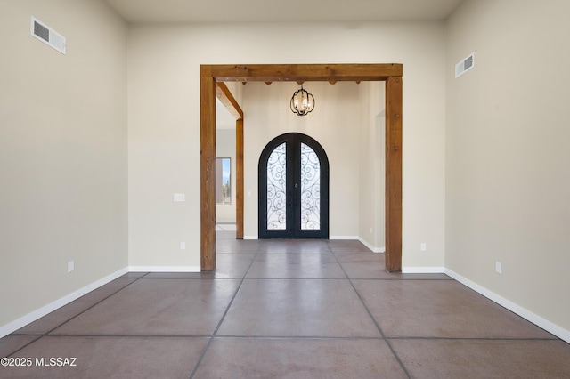 foyer featuring arched walkways, finished concrete flooring, french doors, and visible vents