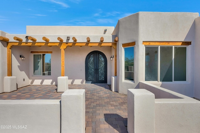 entrance to property with french doors and stucco siding