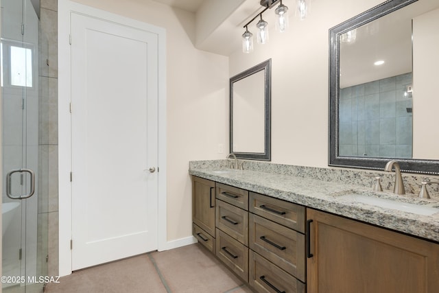 full bath with a sink, baseboards, tile patterned floors, double vanity, and a stall shower