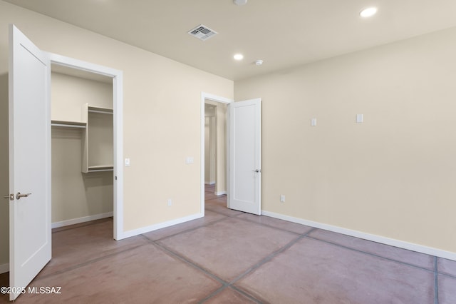 unfurnished bedroom featuring recessed lighting, a walk in closet, visible vents, and baseboards