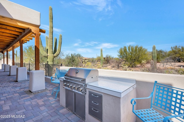 view of patio / terrace featuring exterior kitchen and a grill