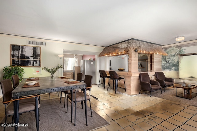 tiled dining space with visible vents and a ceiling fan