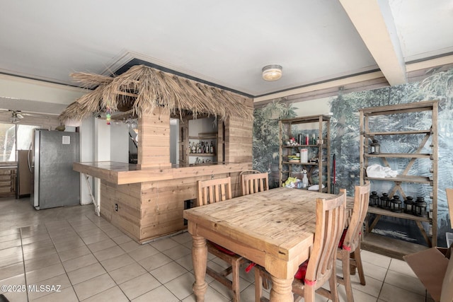 dining area with light tile patterned floors and beam ceiling