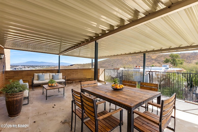 view of patio / terrace featuring outdoor dining area, a mountain view, and an outdoor hangout area