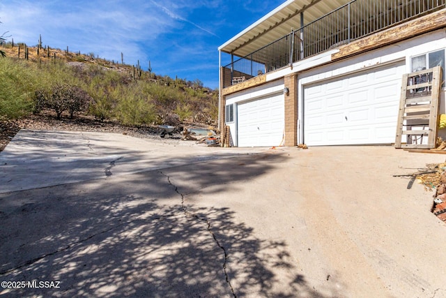 garage featuring concrete driveway