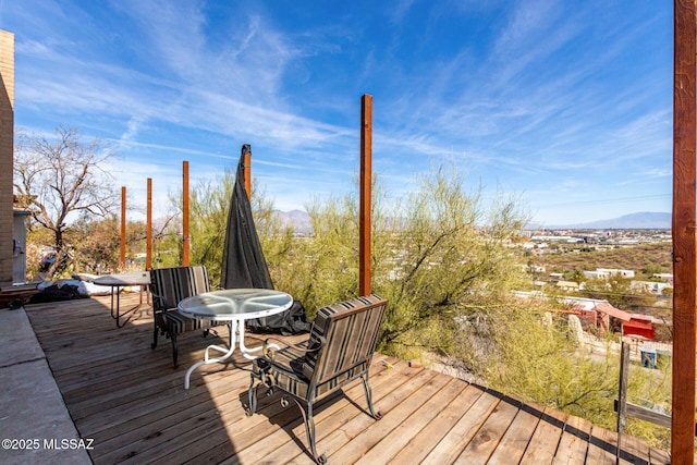wooden deck with a mountain view and outdoor dining area