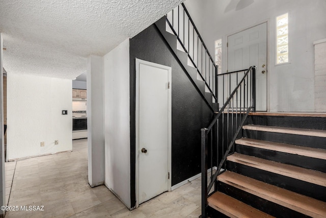 staircase featuring a textured ceiling