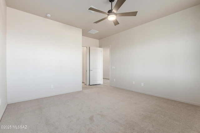 empty room with light carpet, ceiling fan, visible vents, and baseboards