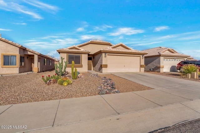 view of front facade with a garage, a tile roof, concrete driveway, and stucco siding