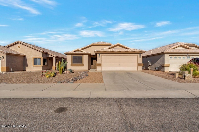 view of front of property with a garage, a tile roof, concrete driveway, and stucco siding