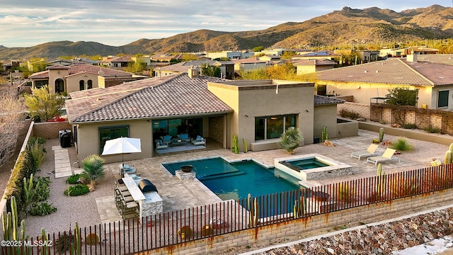 rear view of property with a fenced backyard, a residential view, a tiled roof, a mountain view, and stucco siding