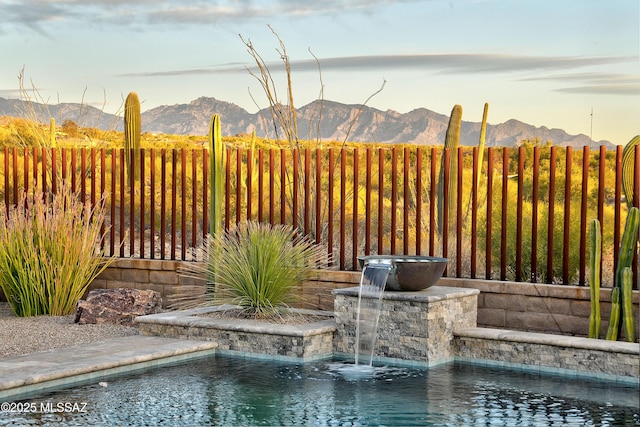 exterior space featuring fence and a mountain view