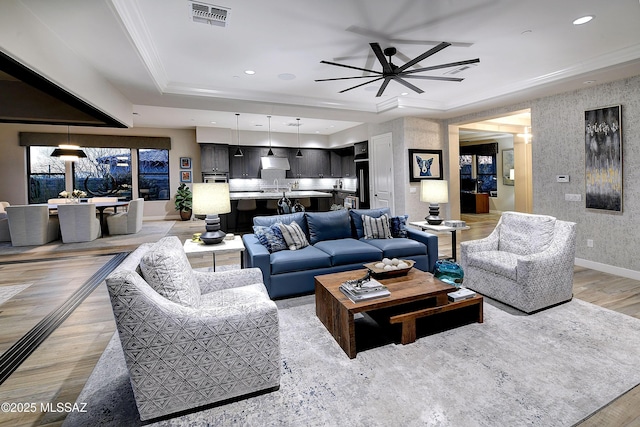 living room with wallpapered walls, baseboards, visible vents, ornamental molding, and recessed lighting