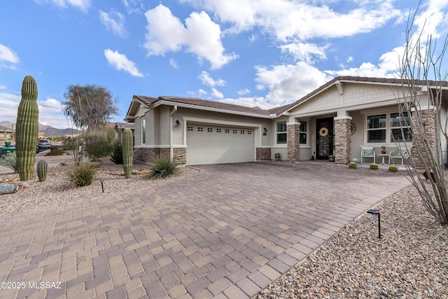 view of front of home featuring a garage, stone siding, decorative driveway, and stucco siding