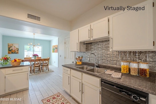 kitchen featuring dark countertops, black dishwasher, visible vents, and a sink