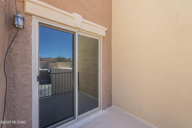 entrance to property with concrete block siding and stucco siding