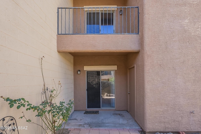 doorway to property featuring a patio and stucco siding