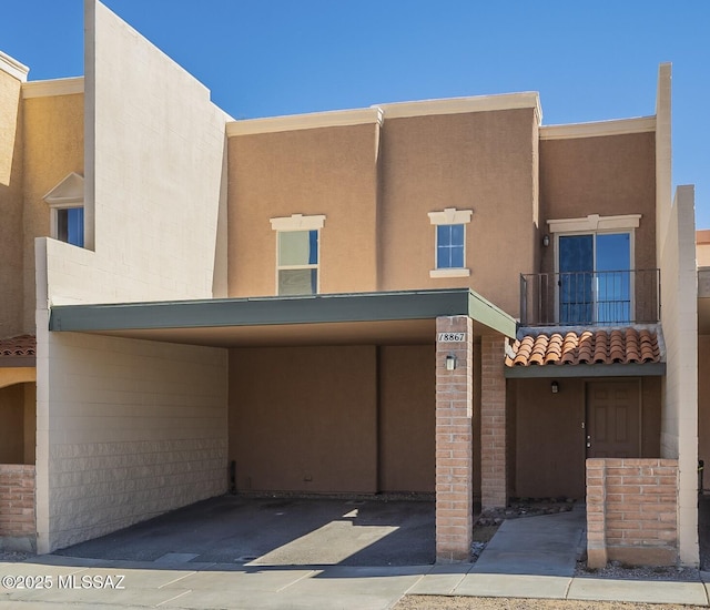 view of front of home with a tiled roof, a balcony, and stucco siding