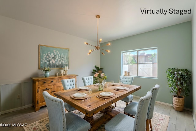 dining area featuring light wood finished floors and an inviting chandelier