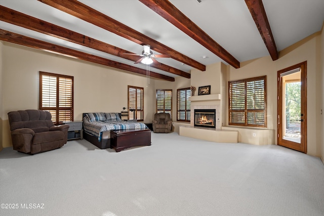 bedroom with carpet flooring, a tiled fireplace, beamed ceiling, and access to outside