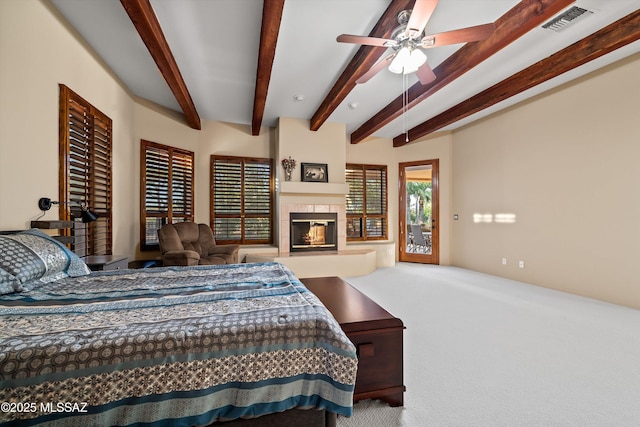 bedroom with beamed ceiling, a tile fireplace, access to outside, and carpet