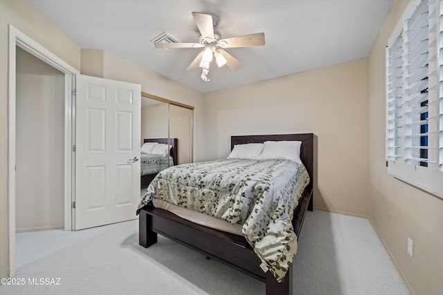 bedroom with light carpet, a closet, and ceiling fan