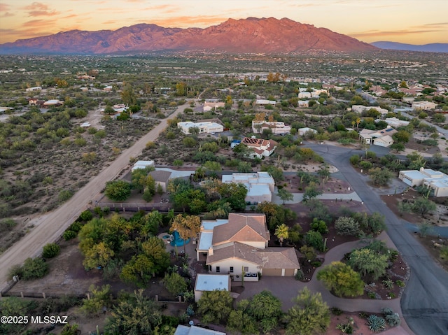 aerial view at dusk featuring a mountain view