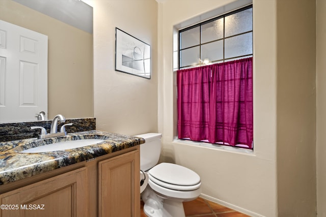 bathroom featuring toilet, tile patterned flooring, and vanity