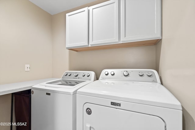 laundry area with cabinets and washing machine and clothes dryer