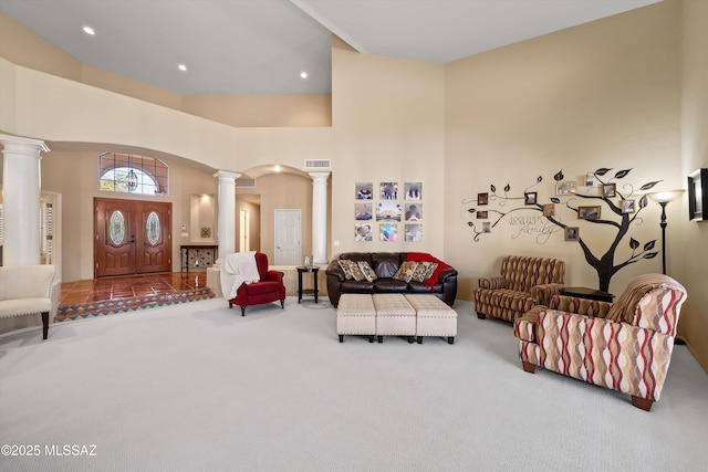 living room with ornate columns, carpet flooring, and a towering ceiling