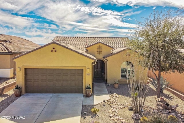 mediterranean / spanish home with a garage, a tile roof, driveway, and stucco siding