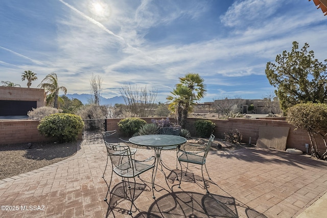 view of patio / terrace with fence private yard, outdoor dining area, and a mountain view