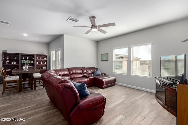 living room with a ceiling fan, light wood-type flooring, visible vents, and baseboards