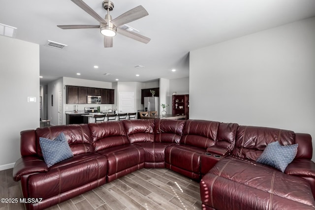 living area with visible vents, a ceiling fan, light wood-style flooring, and recessed lighting