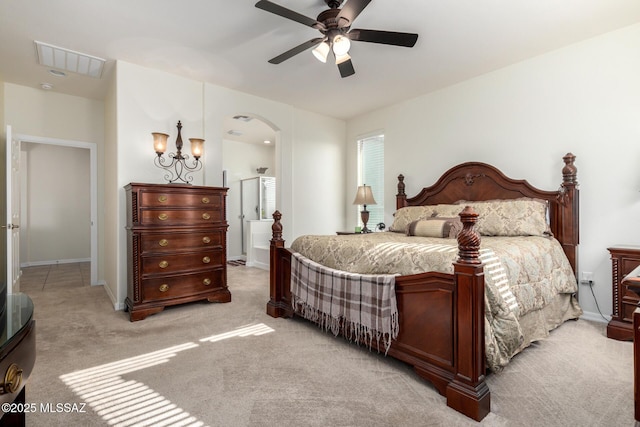 carpeted bedroom featuring ceiling fan with notable chandelier