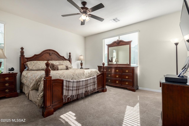 carpeted bedroom featuring multiple windows and ceiling fan