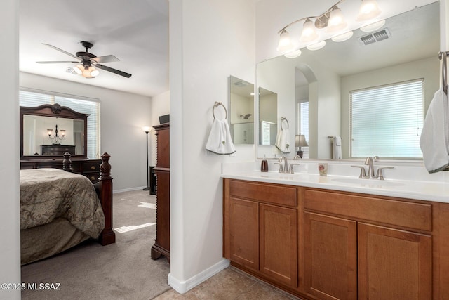 bathroom featuring ceiling fan, vanity, and a healthy amount of sunlight
