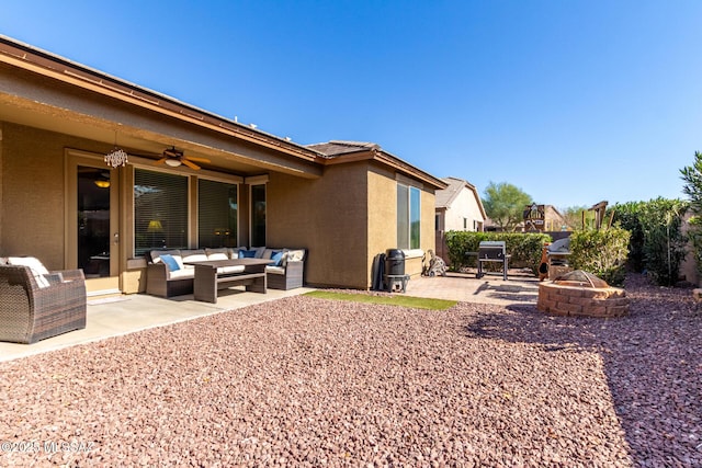 exterior space featuring a patio area, ceiling fan, and an outdoor living space with a fire pit