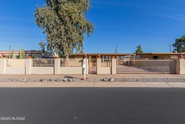 view of front facade with a fenced front yard, a gate, and concrete driveway