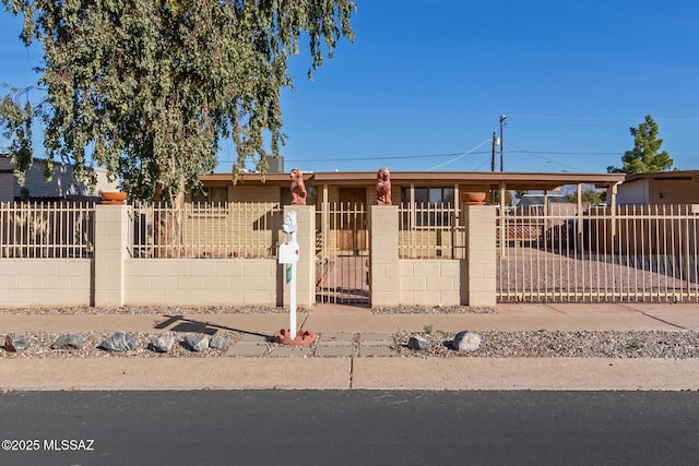 single story home featuring a fenced front yard, a gate, and a carport