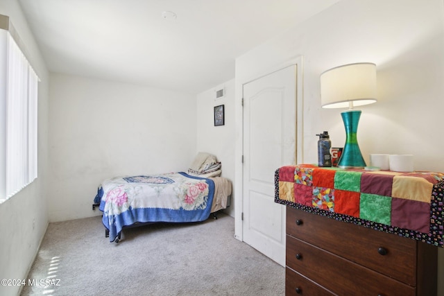 bedroom featuring visible vents and light colored carpet