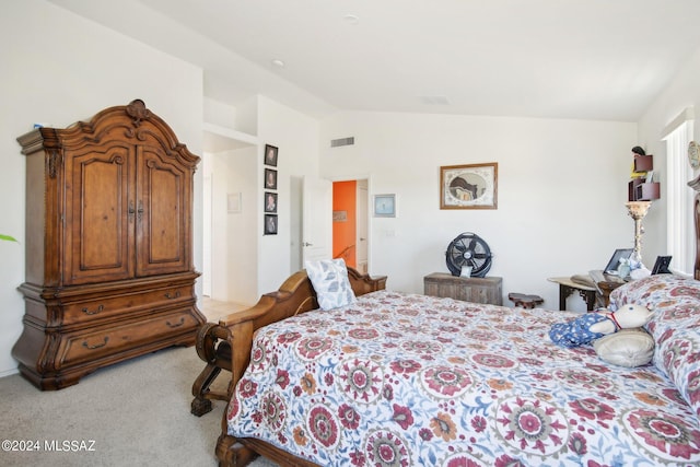 bedroom featuring lofted ceiling, visible vents, and light colored carpet